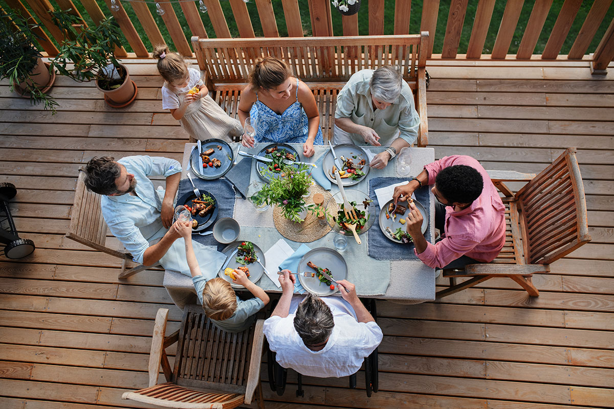 3 generations of family eating outdoors in a tight-knit community.