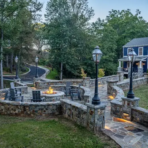 Stone park entrance with gas fire pit and homes in the background
