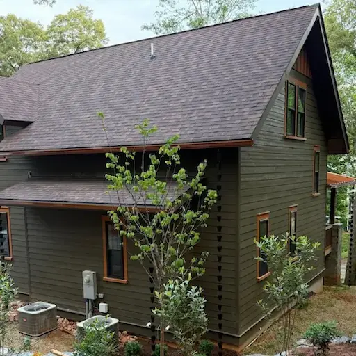 Village House at Sanctuary Village featuring wraparound porch, custom exterior finishes, and landscaped hillside lot