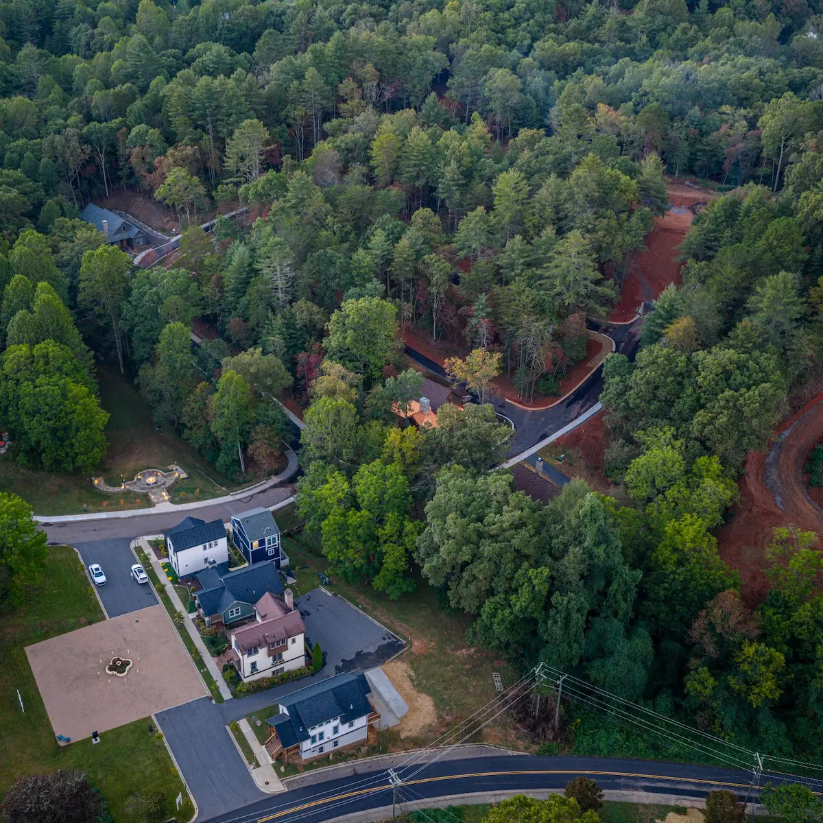 Aerial view of homes and trees with paved roads