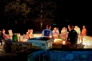 People sitting around a fire pit at night