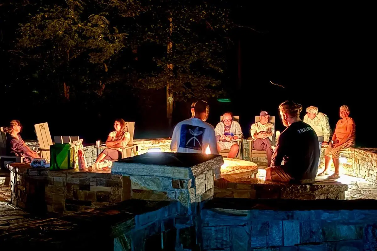 People sitting around a fire pit at night