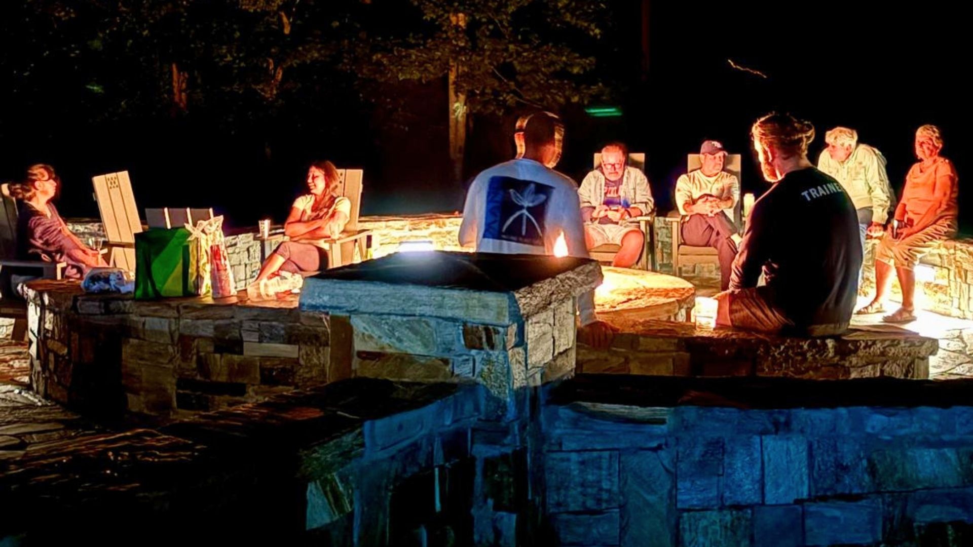 People gathered around a fire pit at night in a community setting in Franklin NC.