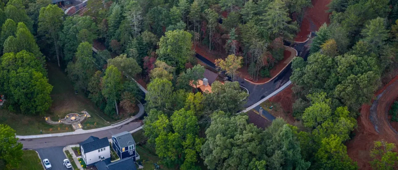 Aerial view of homes and trees with paved roads